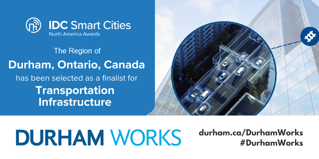 A banner with a light blue background on the left with white text reading IDC Smart Cities North America Awards The Region of Durham, Ontario, Canada has been selected as a finalist for Transportation Infrastructure. A graphic of buildings and roads with cars on it is shown on the right side of the graphic. There’s also a Durham Works branded white banner with black text reading durham.ca/DurhamWorks #DurhamWorks 
