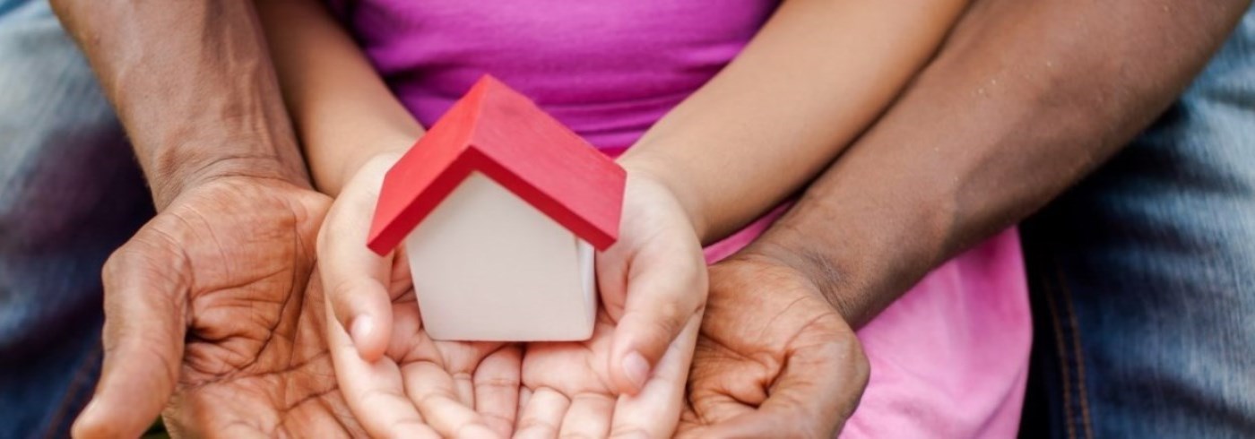 hands holding a small house