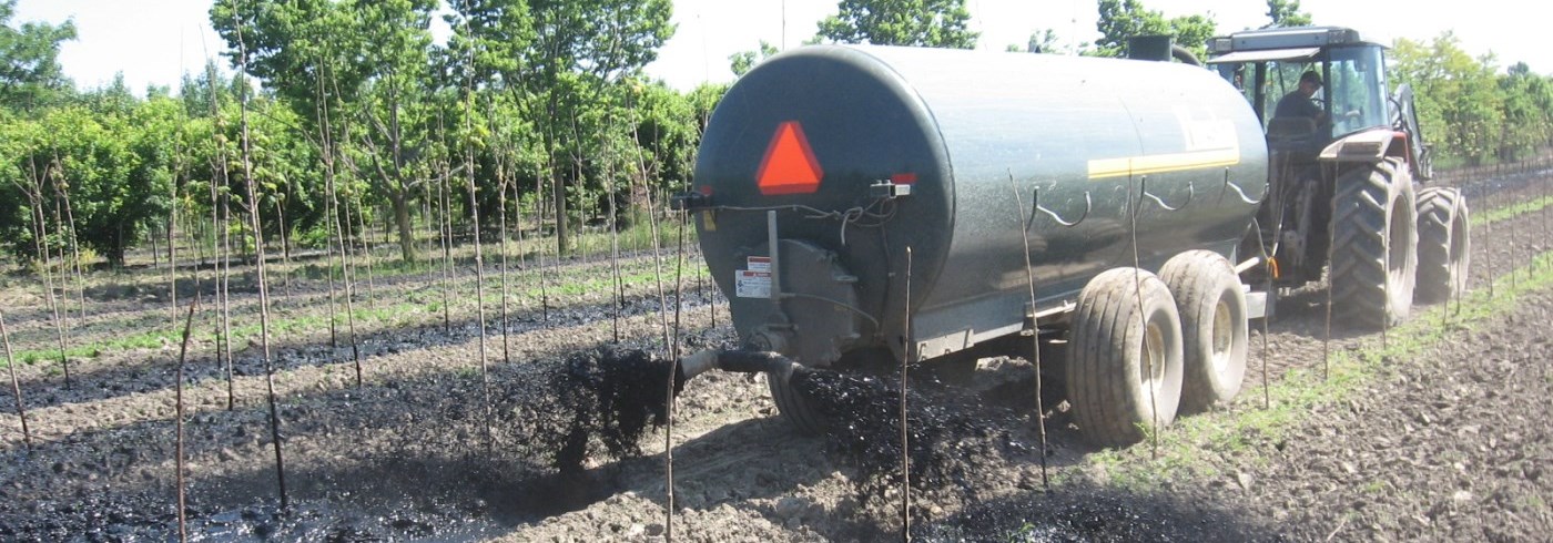 Farm tractor applying sewage biosolids to crop