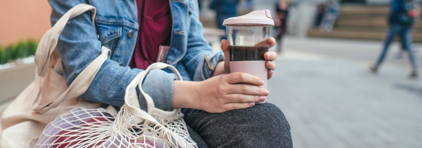 Women holding reusable coffee mug