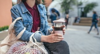 Women holding reusable coffee mug