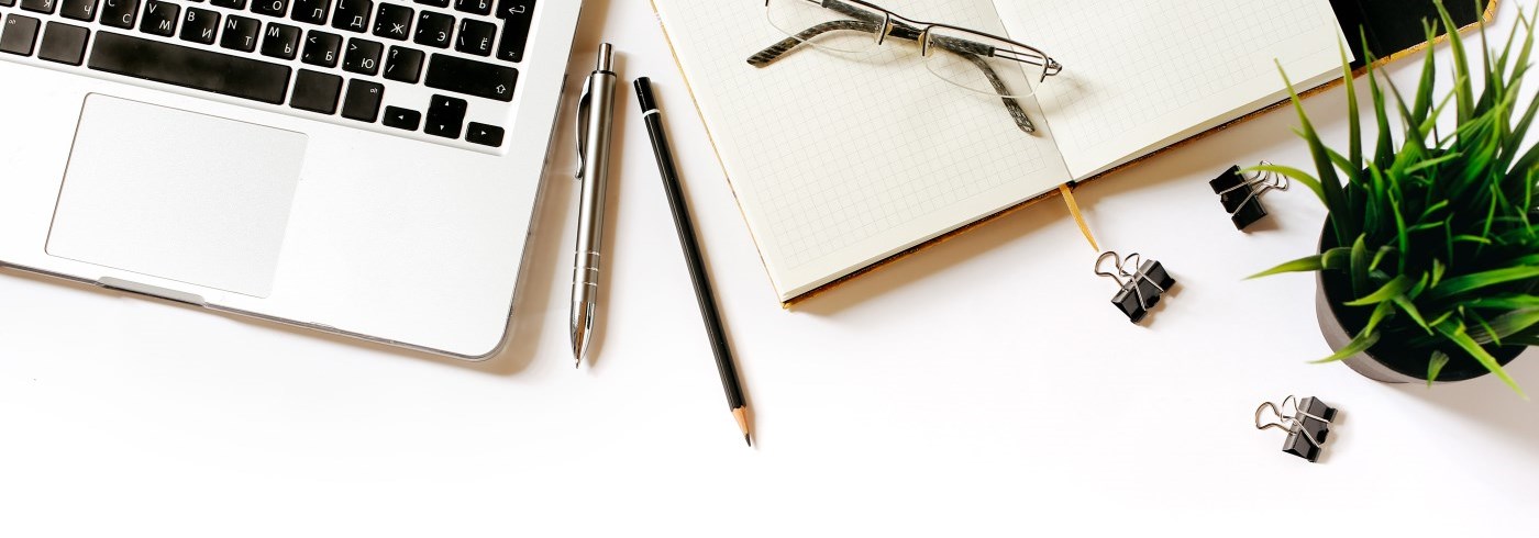 Keyboard, pen, paper, glasses on desk