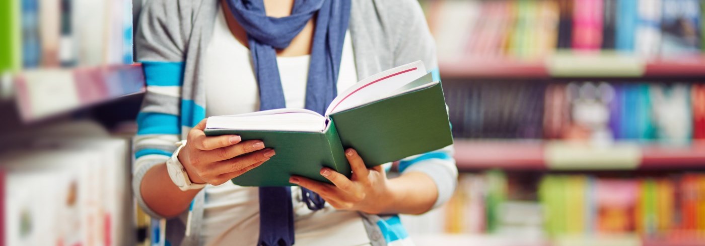 Female reading book at library