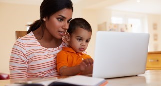 Mom sitting with child in front of laptop