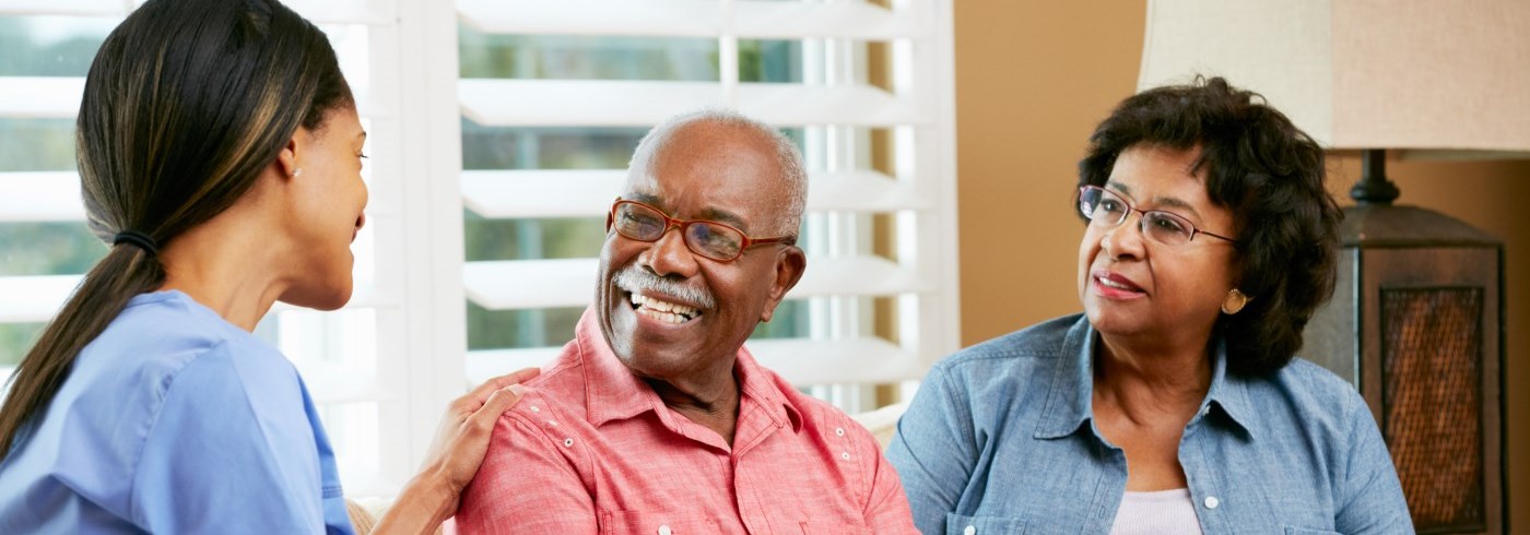 Senior couple sitting on couch with woman