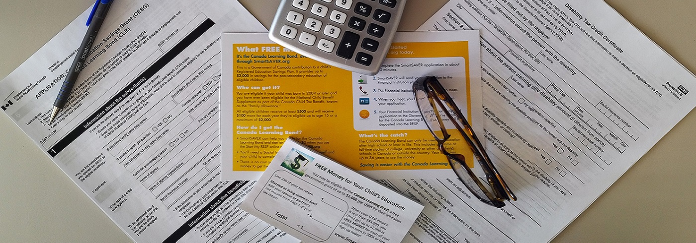 Tax papers, calculator, and glasses on a desk