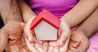 hands holding a small house