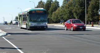 Transit bus and car driving on a road