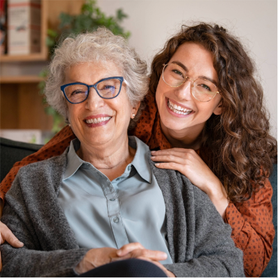 A grandmother and granddaughter smiling at the camera