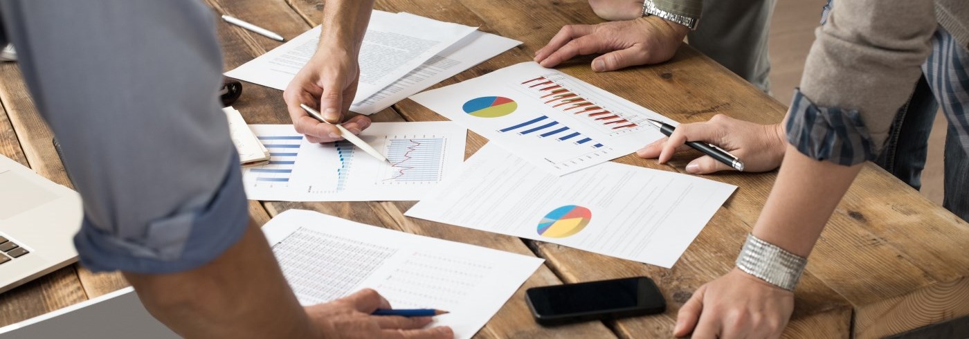 People gathered around a table with financial reports