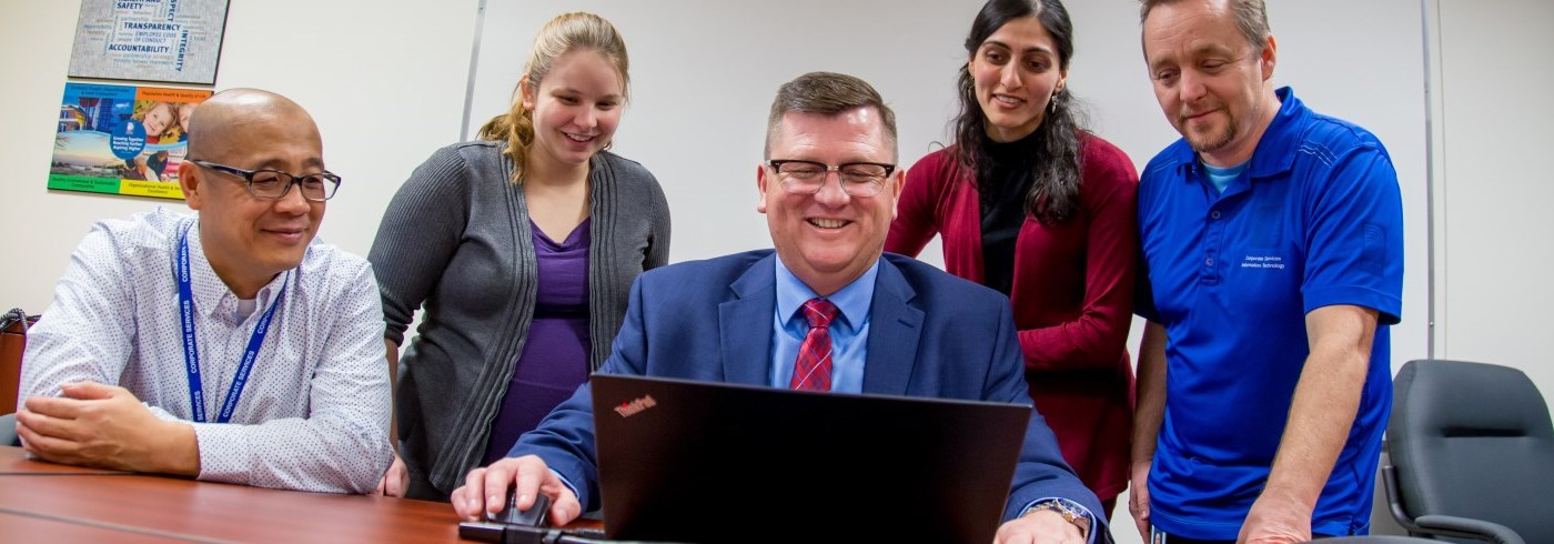 Staff working around a computer