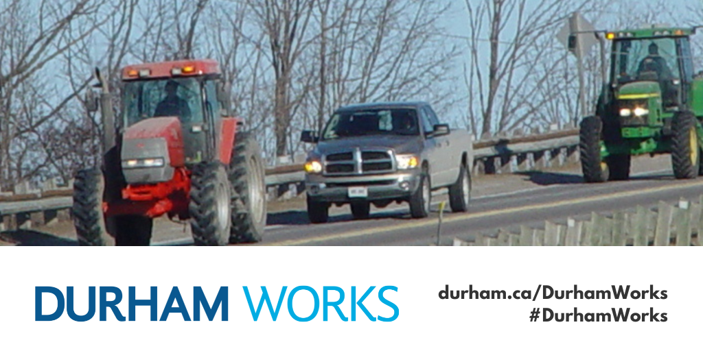 Image of a car and farm equipment driving along a road with text saying, “Durham Works, durham.ca/DurhamWorks #DurhamWorks.”