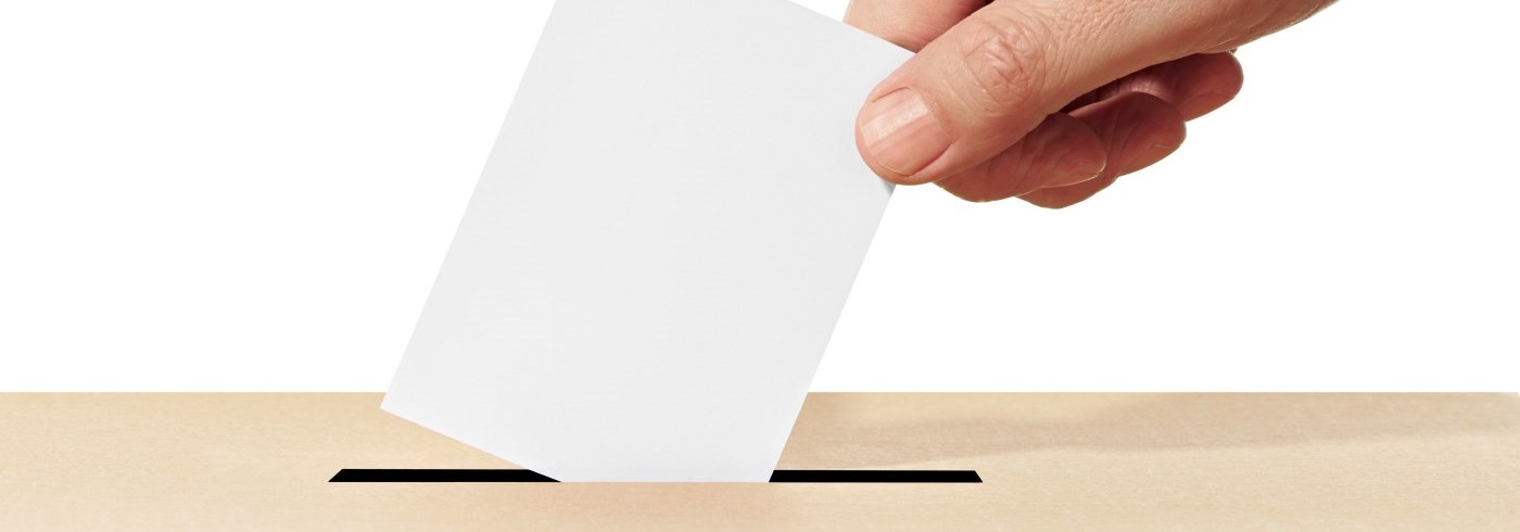 hand putting ballot into box