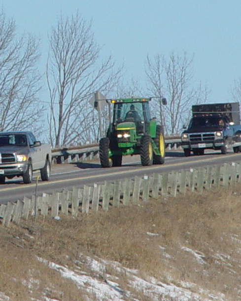 Image showing farm equipment and other vehicles driving down a road.