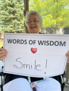 Picture of Emily holding a "Words of Wisdom" sign