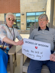 Picture of Joan and Don holding a "Words of Wisdom" sign