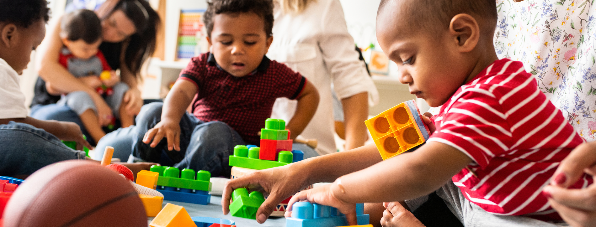 Children and an adult playing and working together.