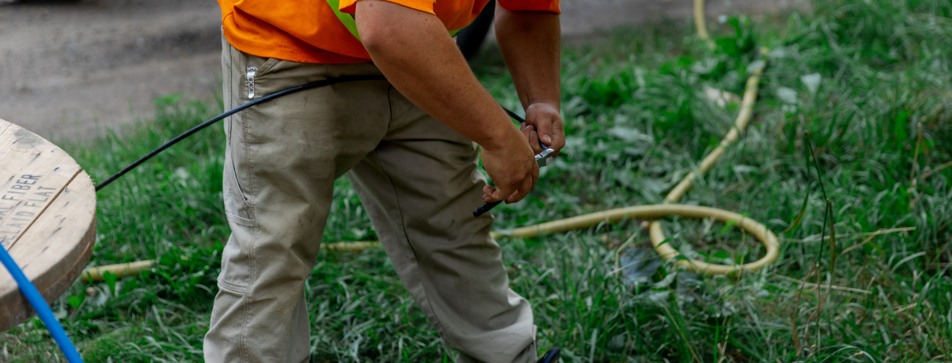An image of man clipping wires with cables in the background.