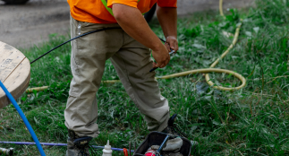 An image of man clipping wires with cables in the background.