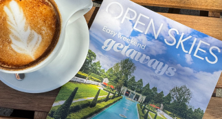 Open Skies guide next to a cup of coffee.