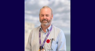 A head shot of Allan with a blurred background.
