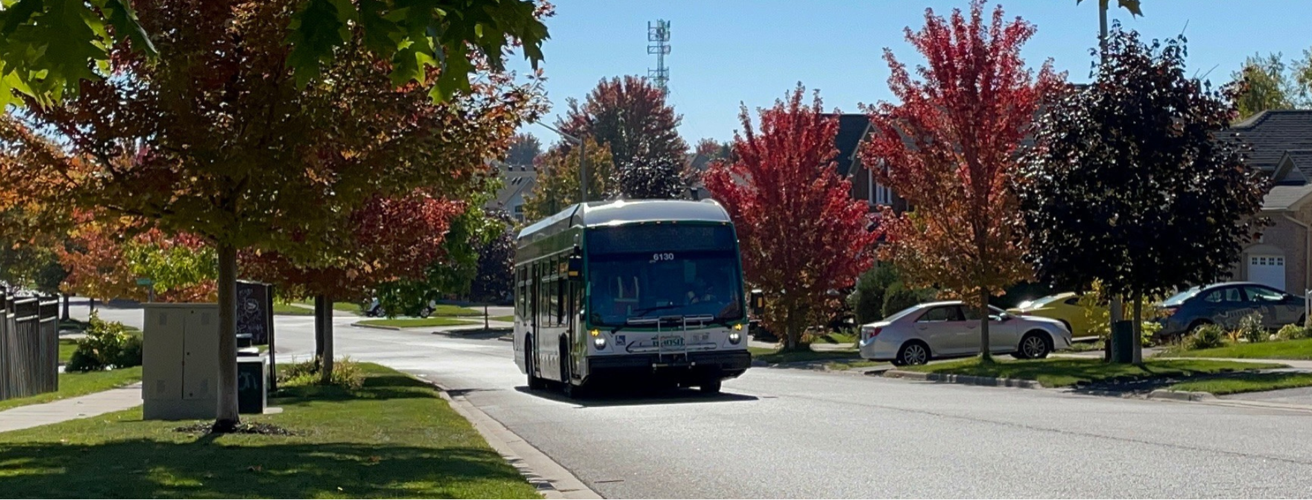 A DRT bus drives down a quiet street in the fall.