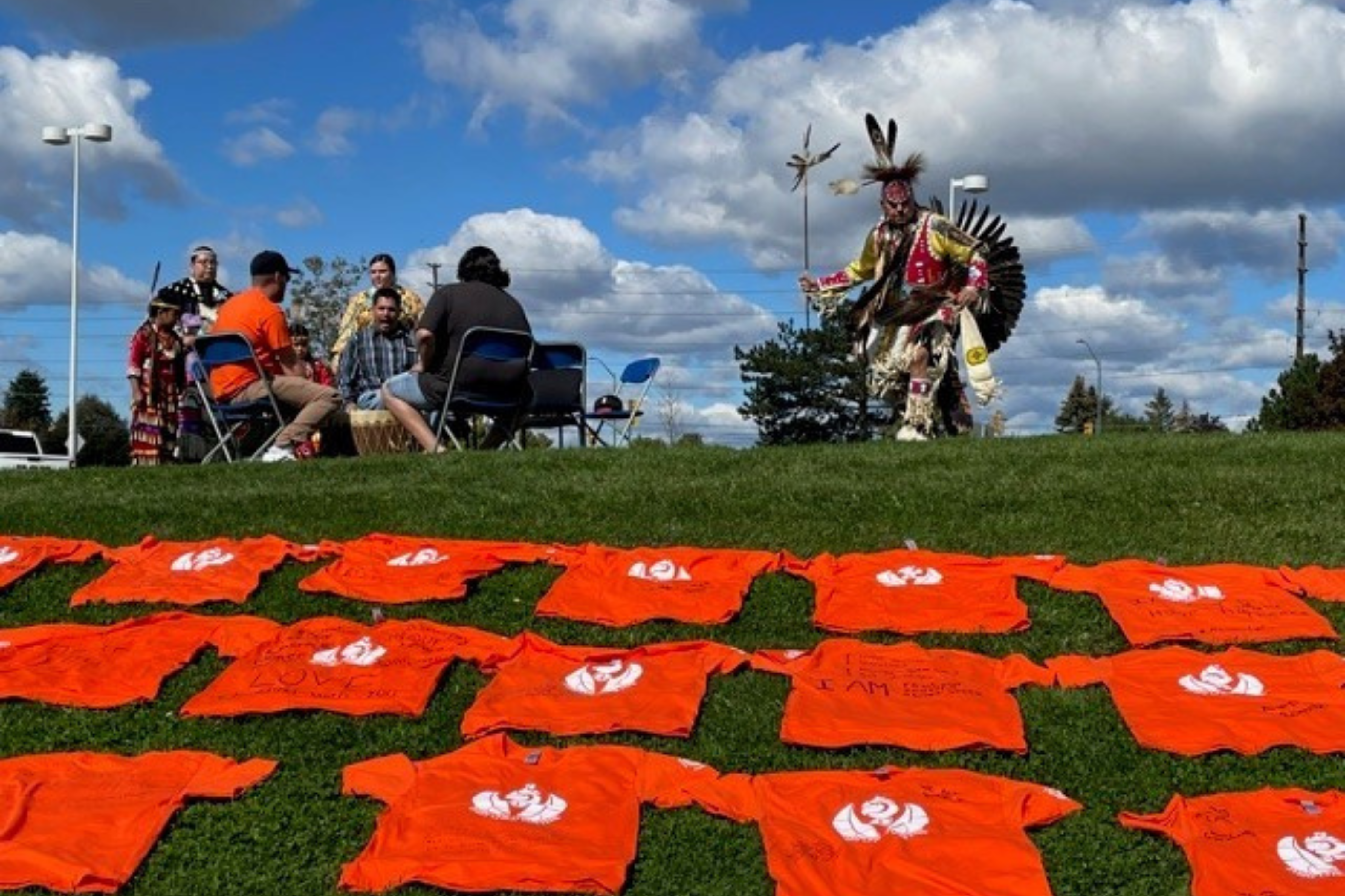 Orange shirts laying on a hill.