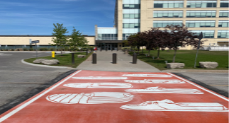 An Orange crosswalk with mocassins in front of Durham Regional Headquarters