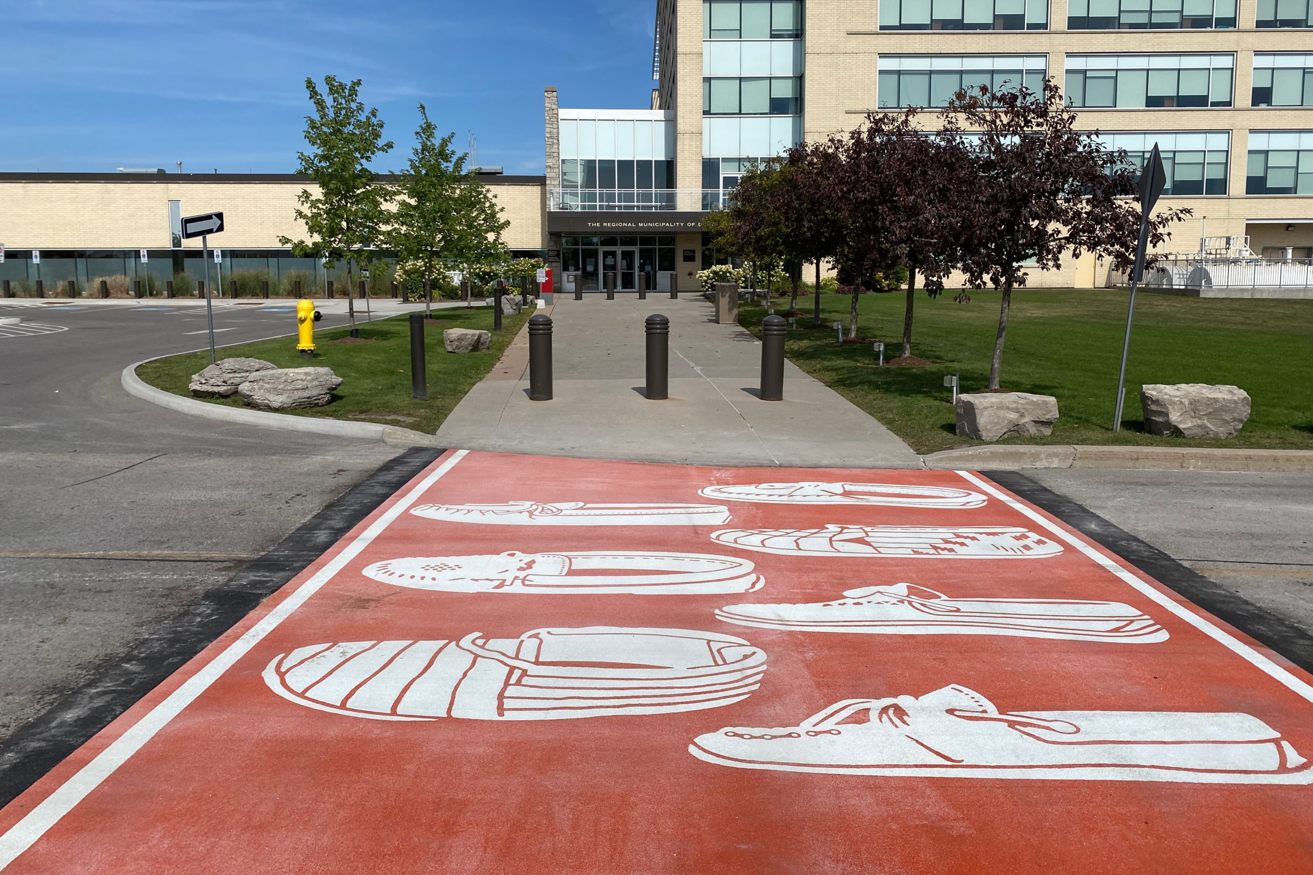 An Orange crosswalk with mocassins in front of Durham Regional Headquarters