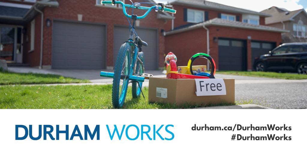 A picture of a bike and a box of items marked as free on the curb of a residential home, with the Durham Works logo and text reading durham.ca/DurhamWorks #DurhamWorks