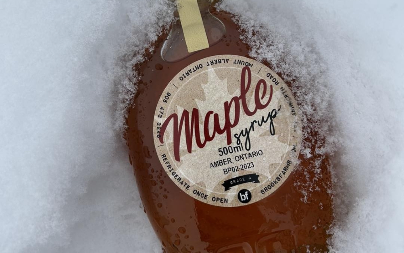 Bottle of maple syrup from Brooks Farm in the snow