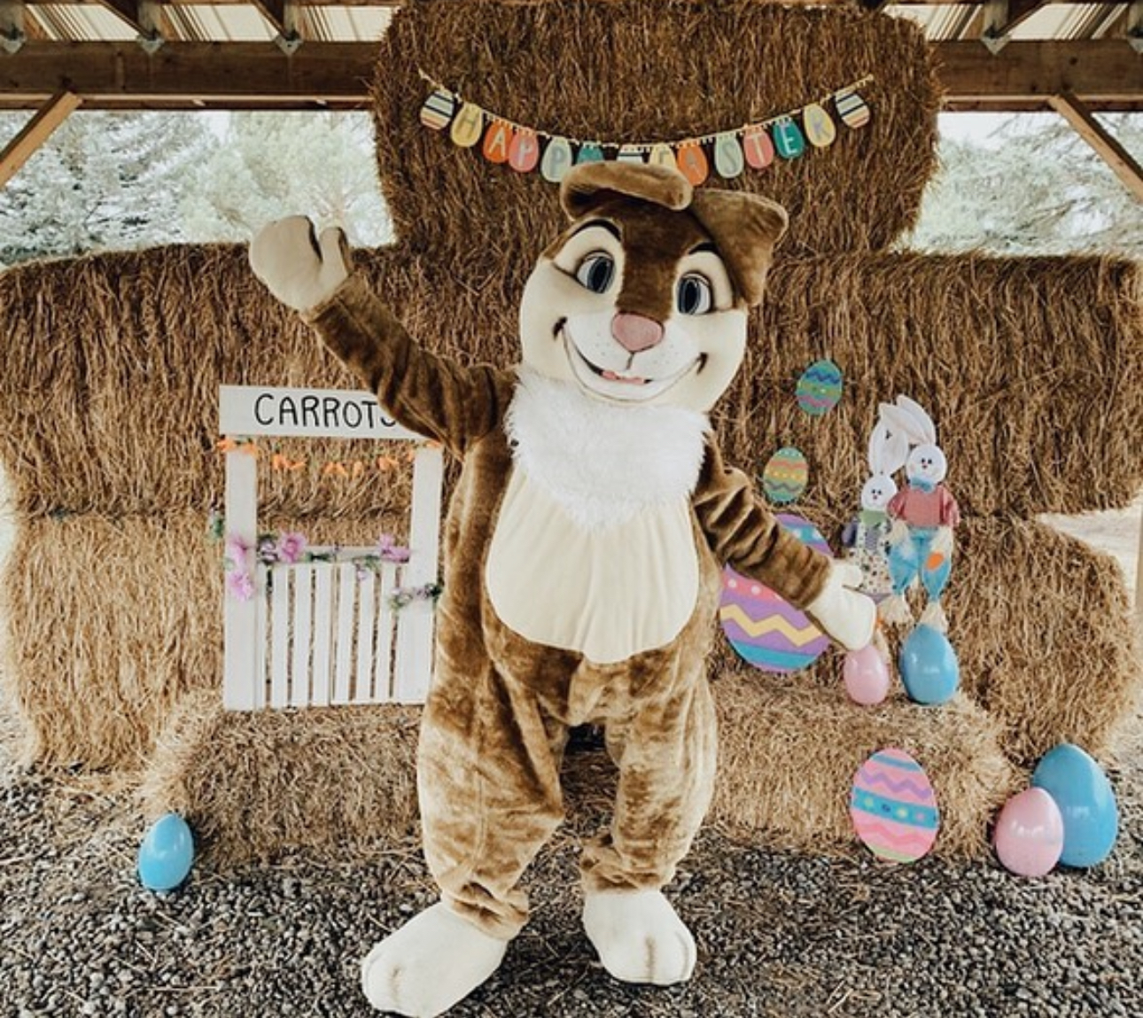 Easter Bunny mascot posing in front of Easter photo opportunity set up