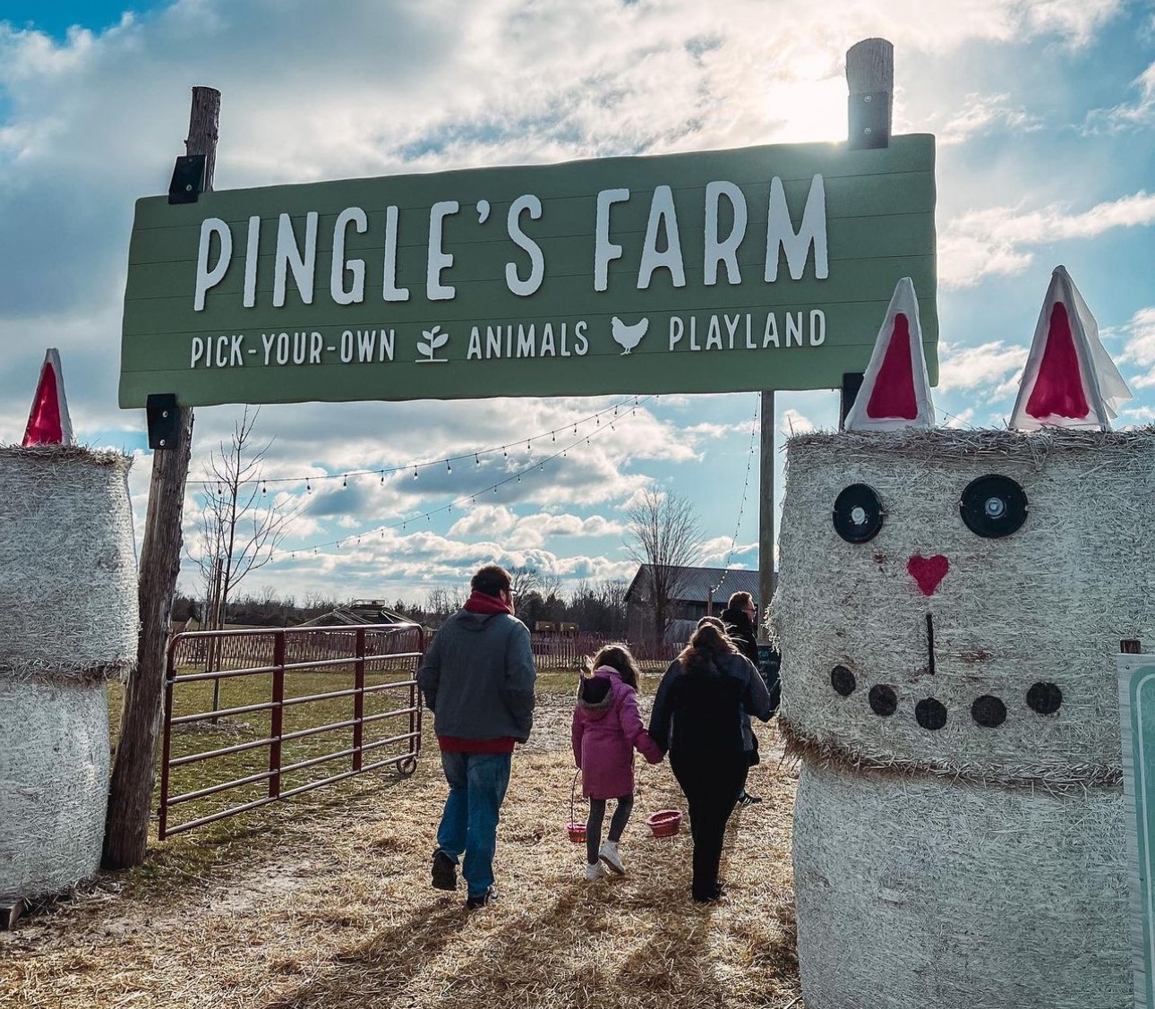 Photo of a family entering farm under a Pingle's Farm sign