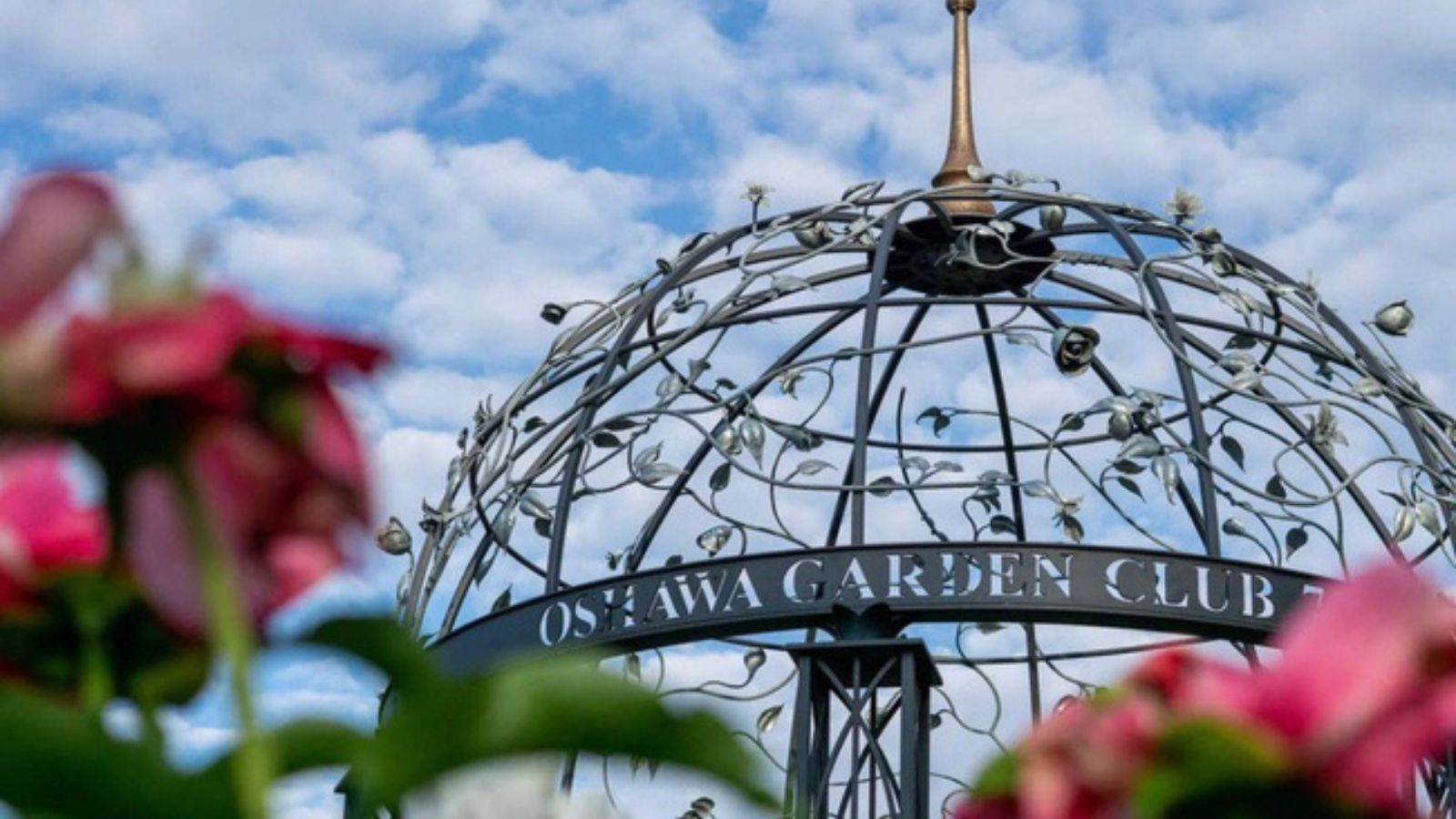 Large bird cage monument with blurred flowers in front 