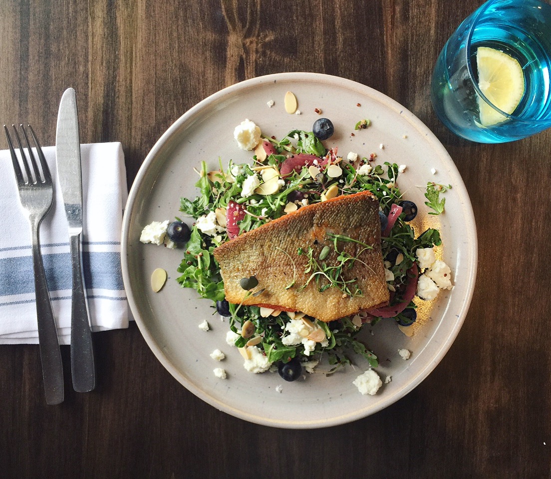 Plate of food featuring a piece of crispy fish and bright green vegetables