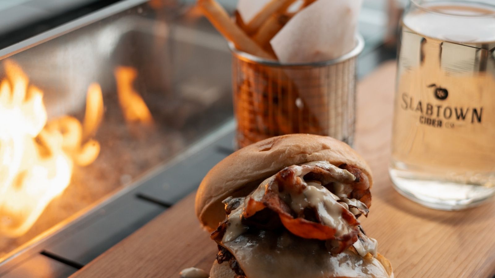Burger and cider by an outdoor firepit at Slabtown Cider in Uxbridge, Ontario