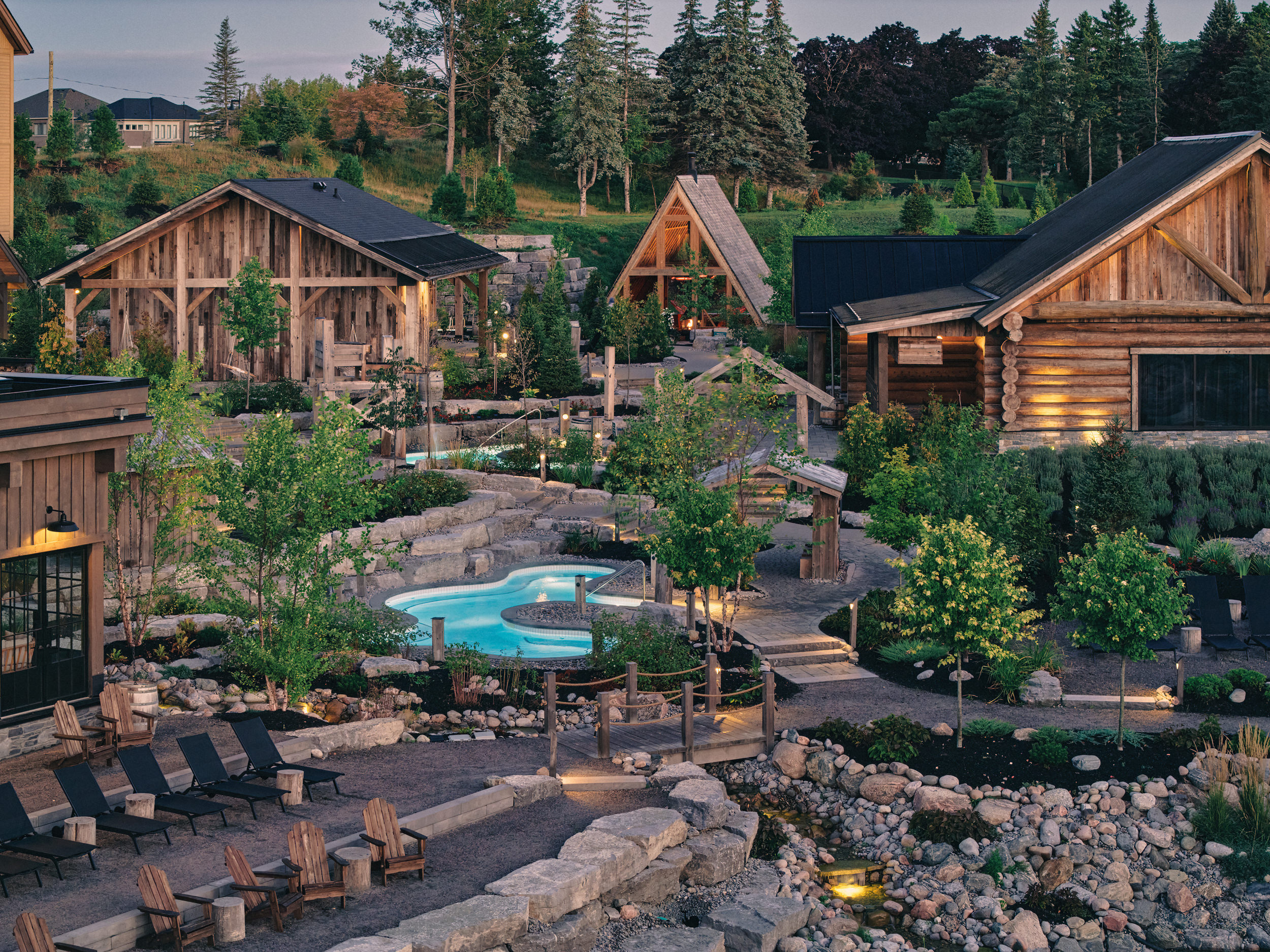 View looking down on a luxury spa village with wooden cabins and pools