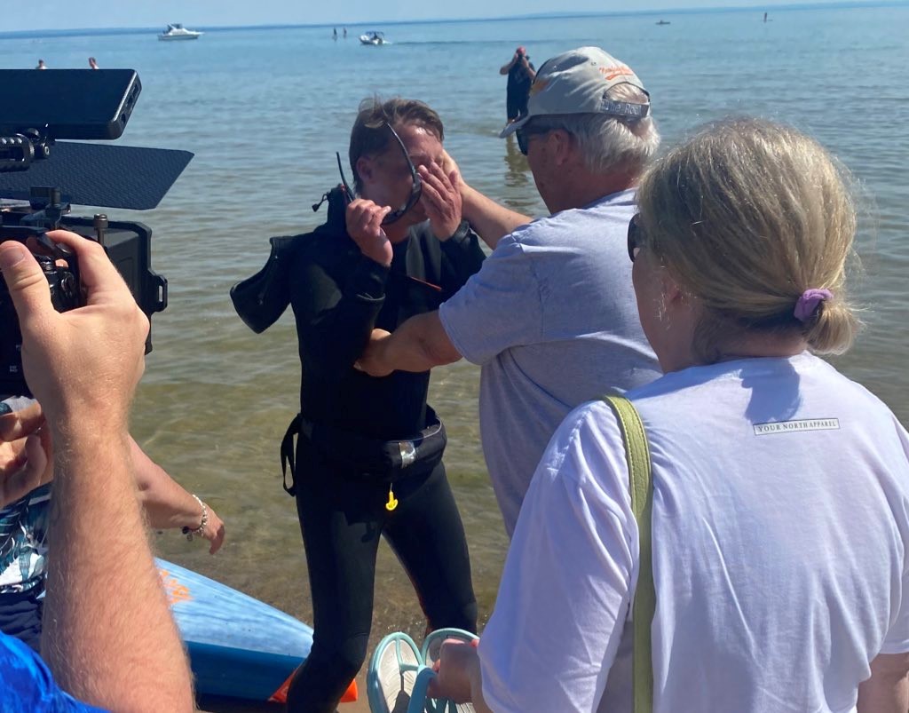 Mike Shoreman arriving on shore surrounded by cameras