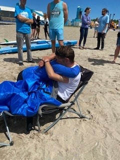 Mike Shoreman receives a hug while sitting in a chair