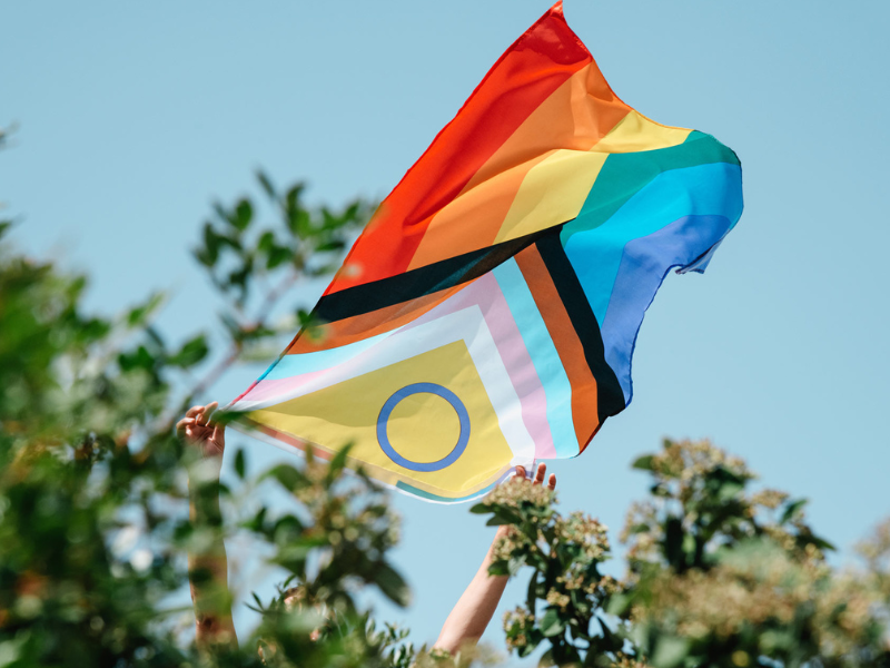 Image of an inclusive Pride flag flying in the wind