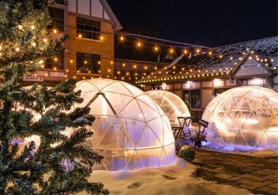 Outdoor dining domes surrounded by snow and holiday lights at Deer Creek in Ajax, Ontario