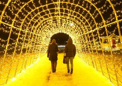 Couple walking through a tunnel of lights at Holiday in the Hills in Orono, Ontario