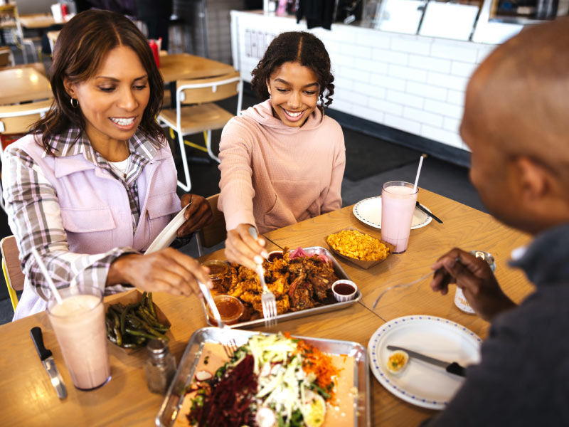 Family dining in a restaurant and sharing food.