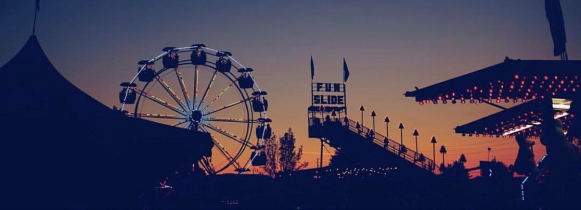 Ferris wheel and midway games at sunset at a fall fair in Durham Region, Ontario, Canada