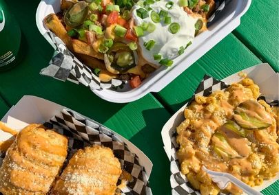 Food from a food truck sitting on a green picnic table