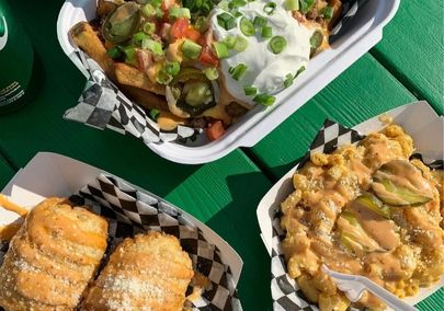 An aerial image of food from a food truck sitting on a green picnic table