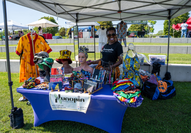A vendor smiling at their vendor booth.