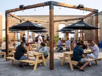 A lakeside beer garden full of people on a sunny, summer day 