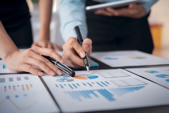 Hands analyzing charts and graphs on documents