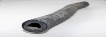 Close-up of a metal pipe with a hollow circular opening on a white surface